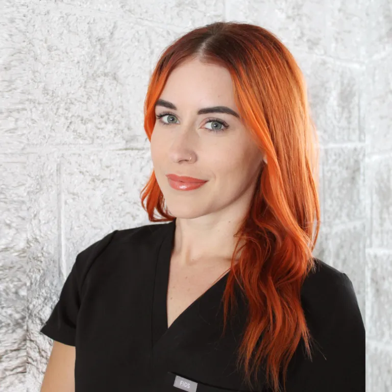 Plastic surgery center professional with red hair in a black uniform.