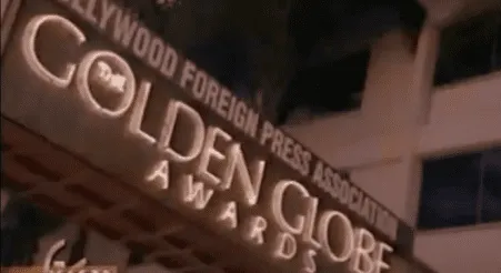 Exterior of a building with Golden Globe Awards signage at night.