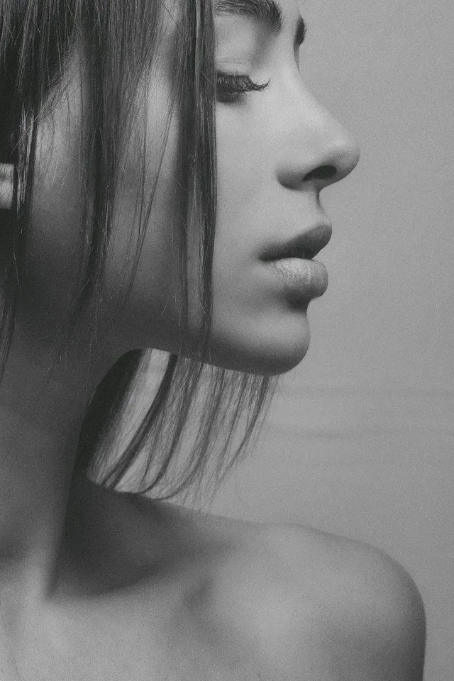 Profile view of a woman's face showcasing a well-defined nose and smooth skin.