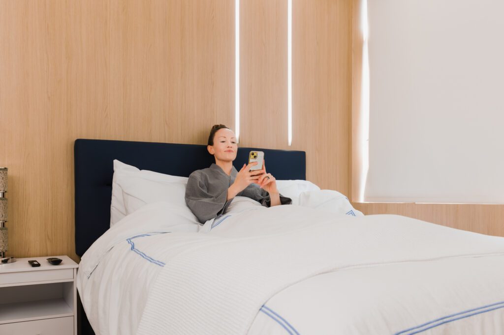 Woman relaxing in a recovery room bed at a plastic surgery center.