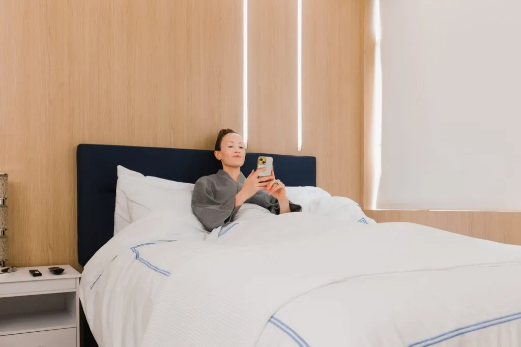 Woman relaxing in a recovery room bed at a plastic surgery center.