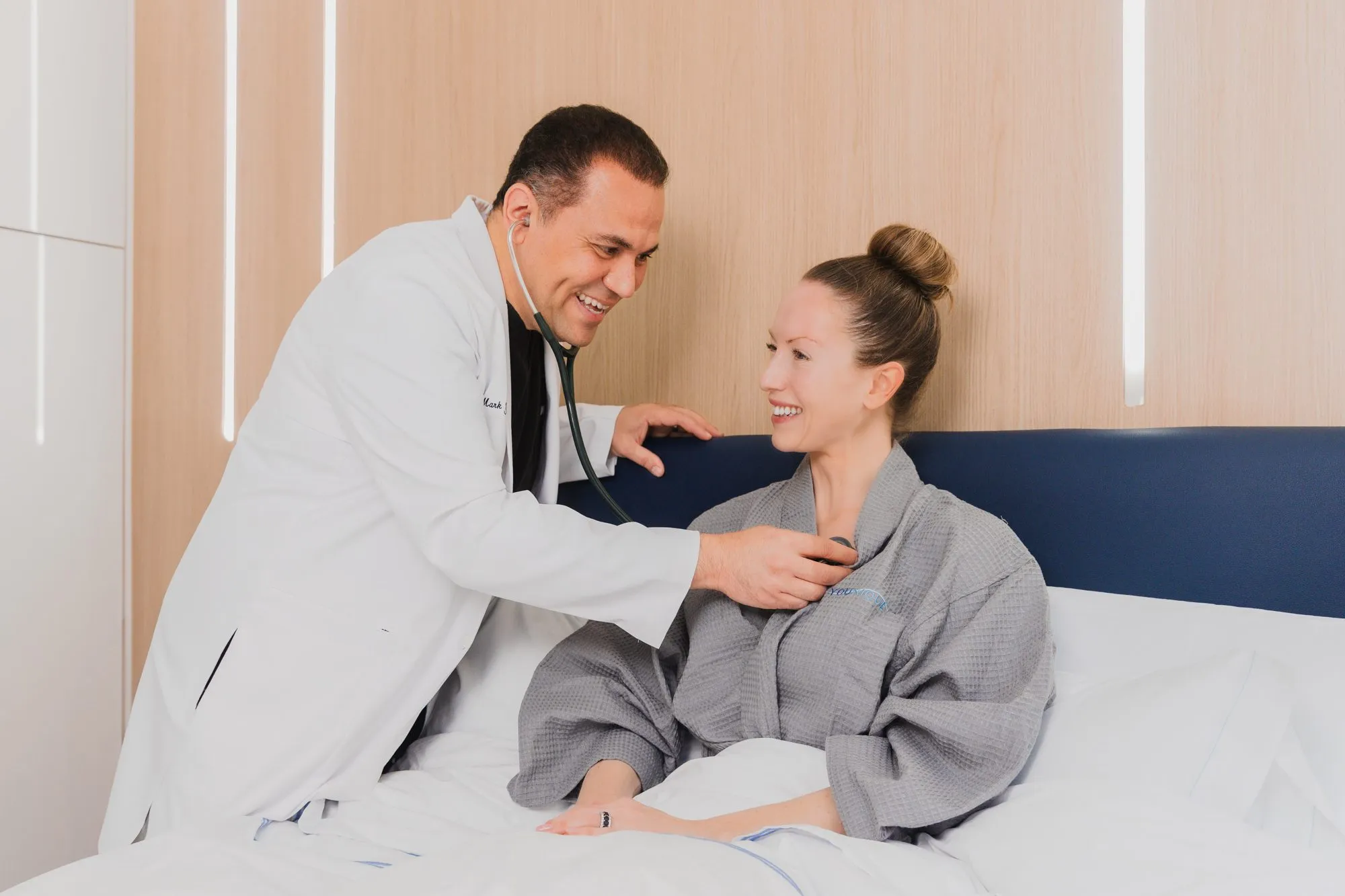 Doctor examining a smiling patient in a plastic surgery center.