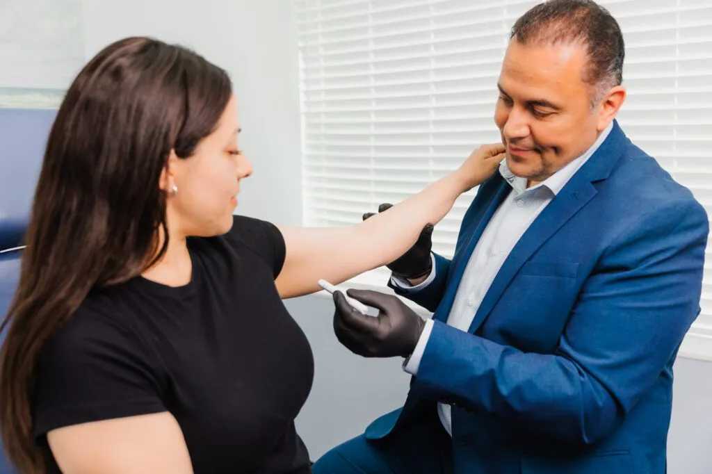 Plastic surgeon consulting with a patient in an office setting.
