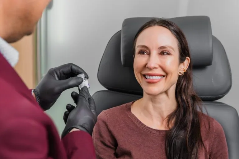 Woman smiling during a consultation at a plastic surgery center.