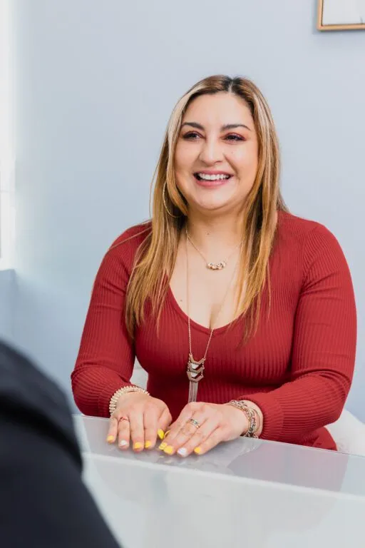 Smiling woman discussing options at a plastic surgery consultation.