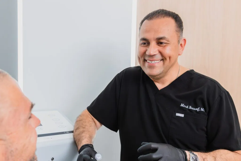 Plastic surgeon consulting with a patient in a clinic setting.