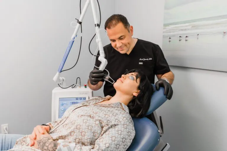 Doctor performing a laser treatment on a patient at a plastic surgery center.