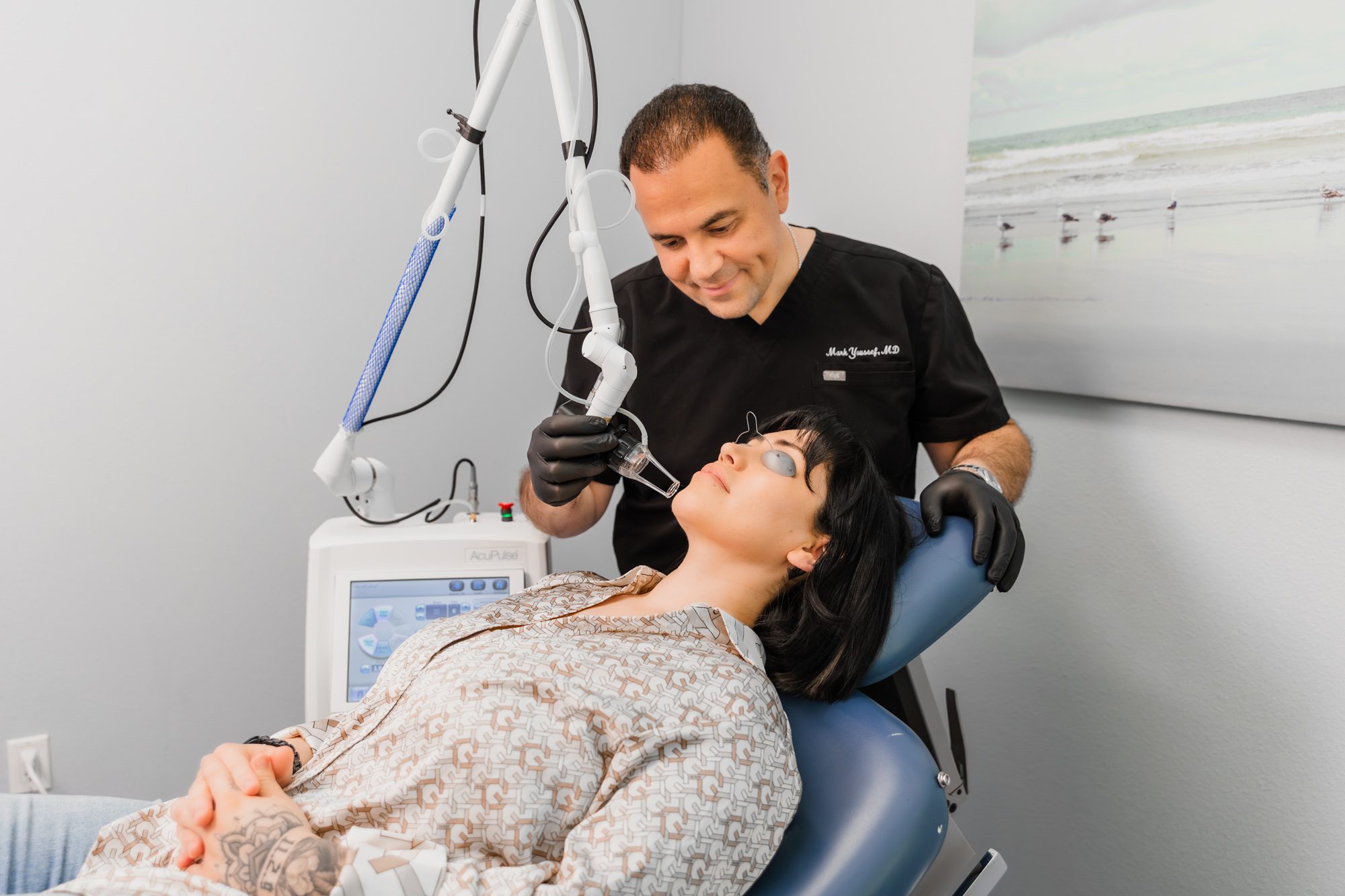 Doctor performing a laser treatment on a patient at a plastic surgery center.