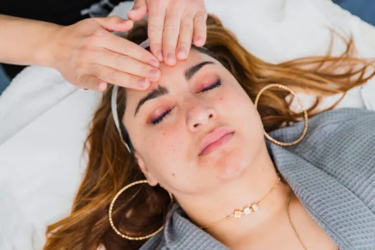 Person receiving a relaxing facial massage at a plastic surgery center.