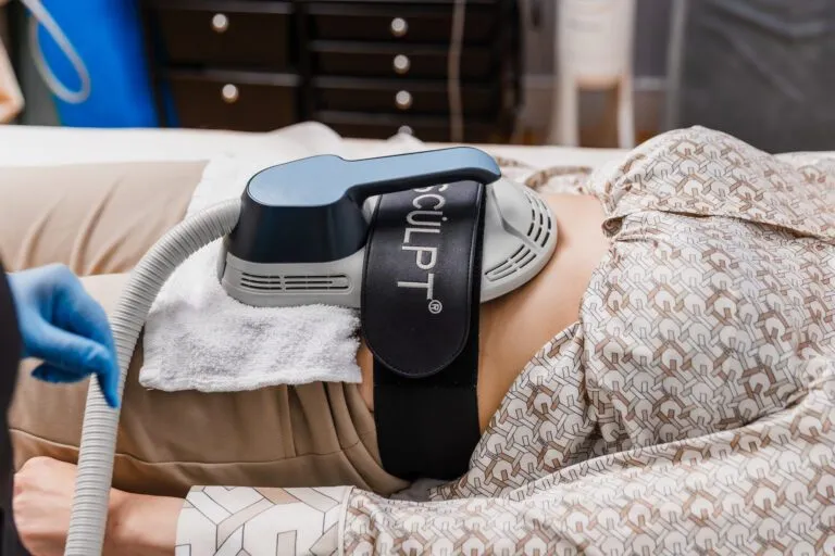 Non-invasive body contouring treatment in progress with EM sculpt device.