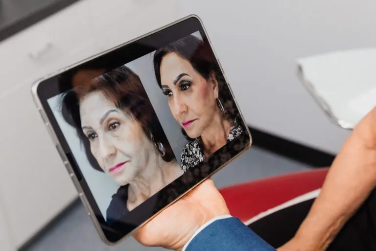 Tablet displaying before and after facial enhancement photos at a plastic surgery center.