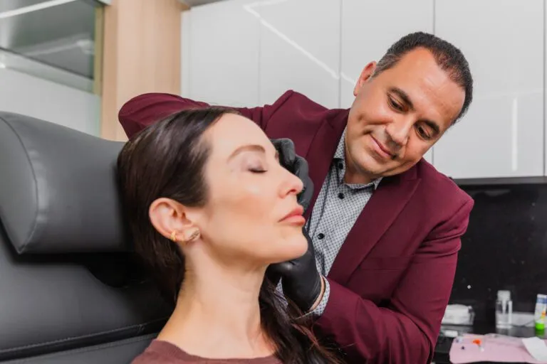 Doctor performing a non-surgical cosmetic procedure on a patient at a plastic surgery center.