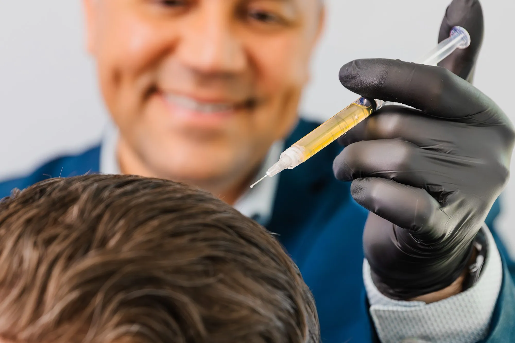 Doctor performing PRP injection for hair restoration.