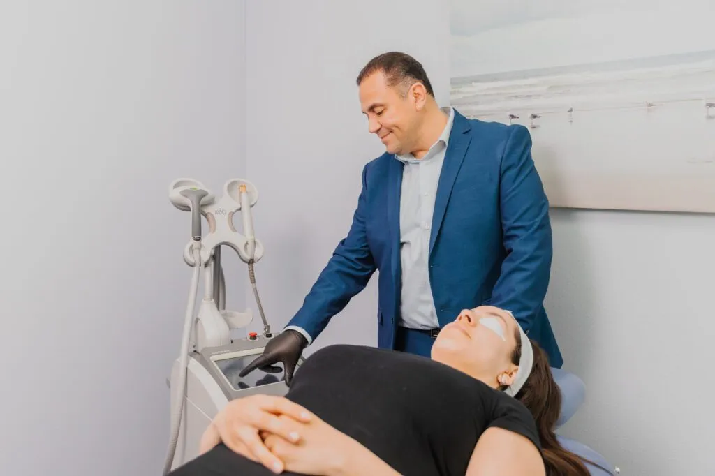 Doctor performing a laser treatment on a patient at a plastic surgery center.