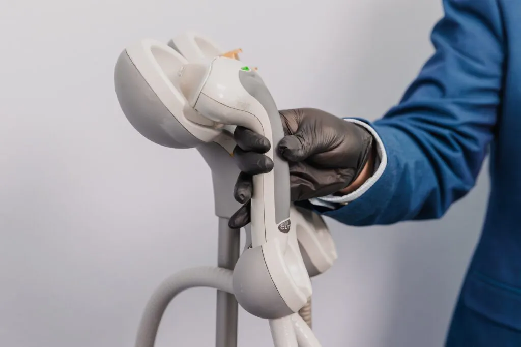 Medical professional holding a laser therapy device at a plastic surgery center.