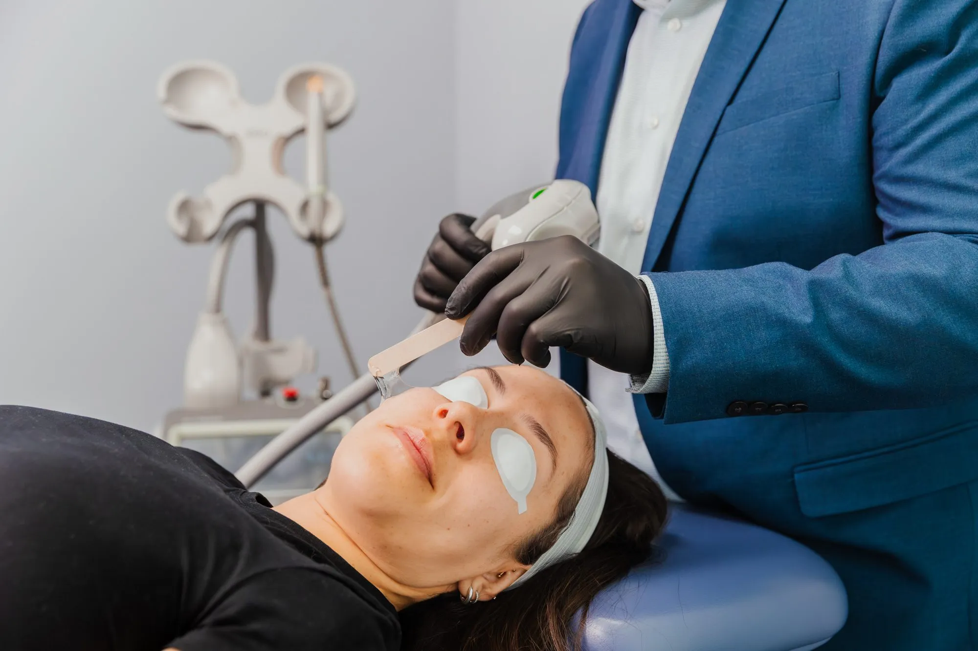 Patient receiving laser skin treatment at a plastic surgery center.