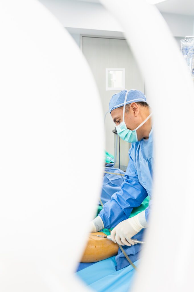 Plastic surgeon performing a procedure in an operating room.