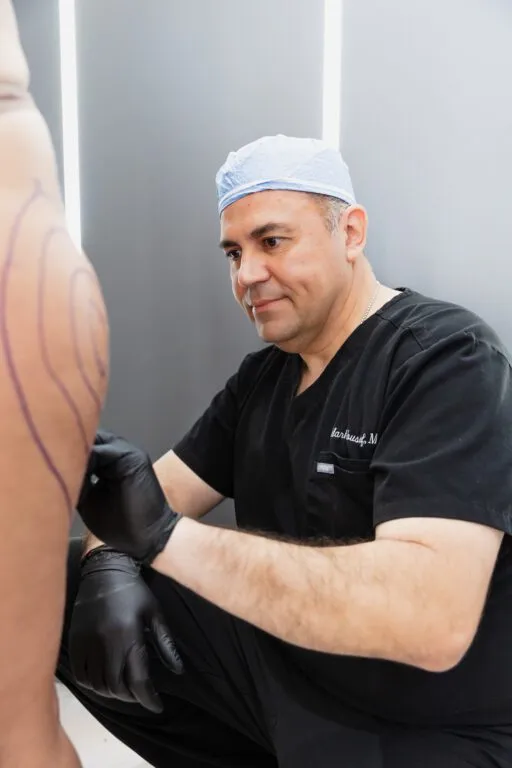 Plastic surgeon marking patient's skin before procedure.