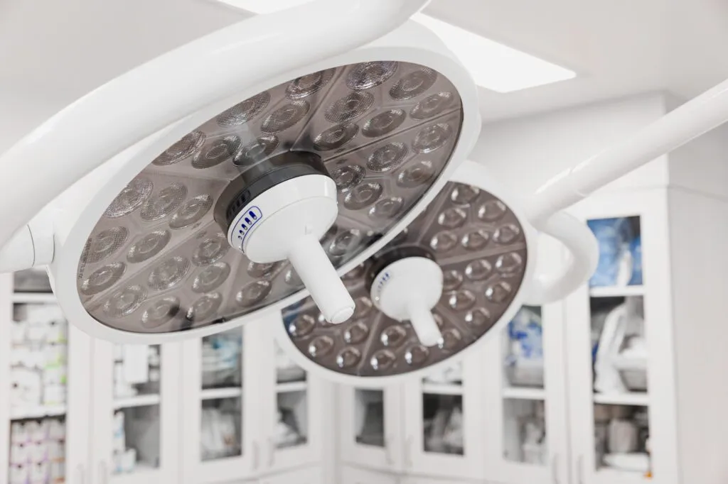 Modern surgical lights in a clean plastic surgery operating room.