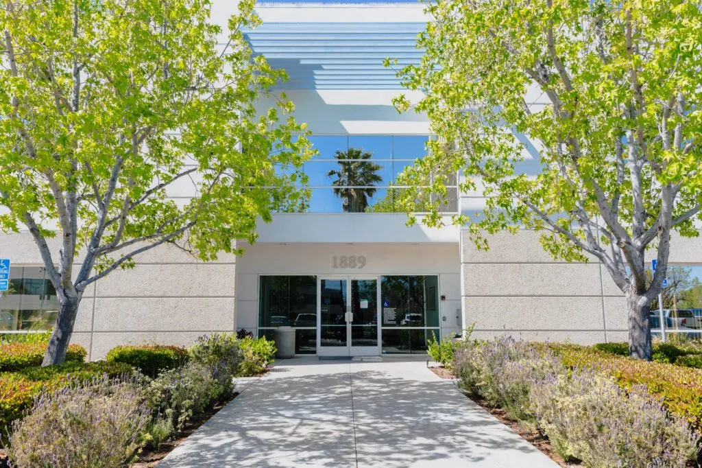 MEDSPA in OXNARD CA - picture of the modern exterior of the plastic surgery center with trees and shrubs.