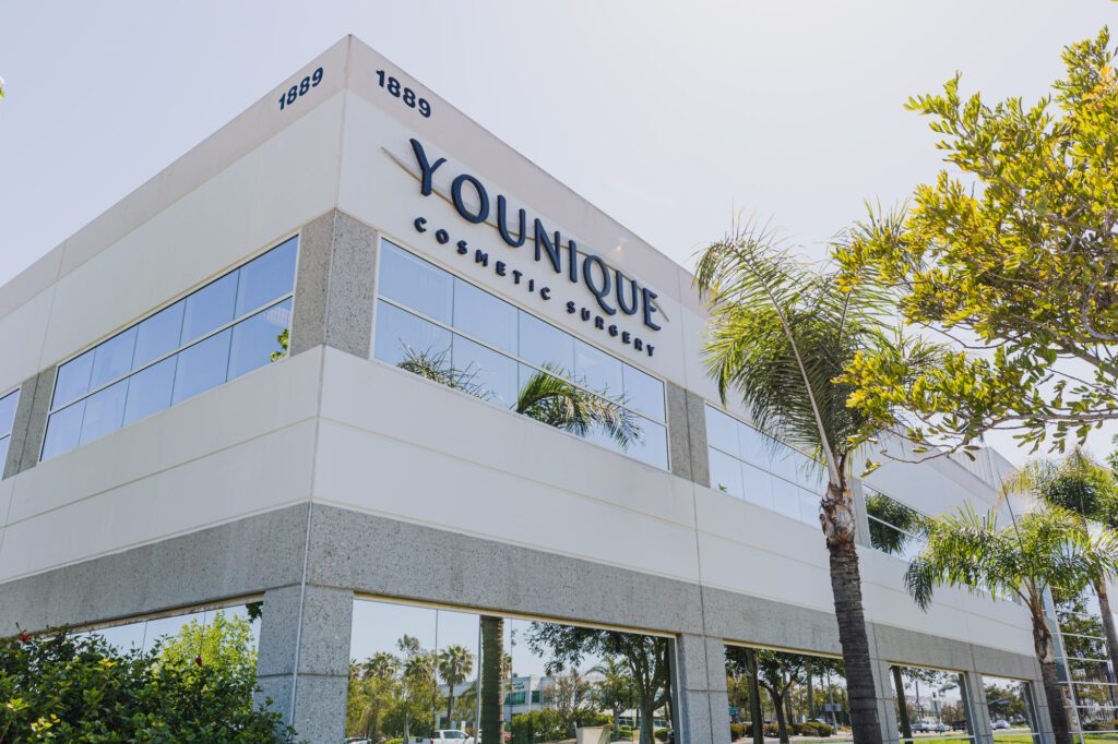 Modern building of a cosmetic surgery center surrounded by palm trees.