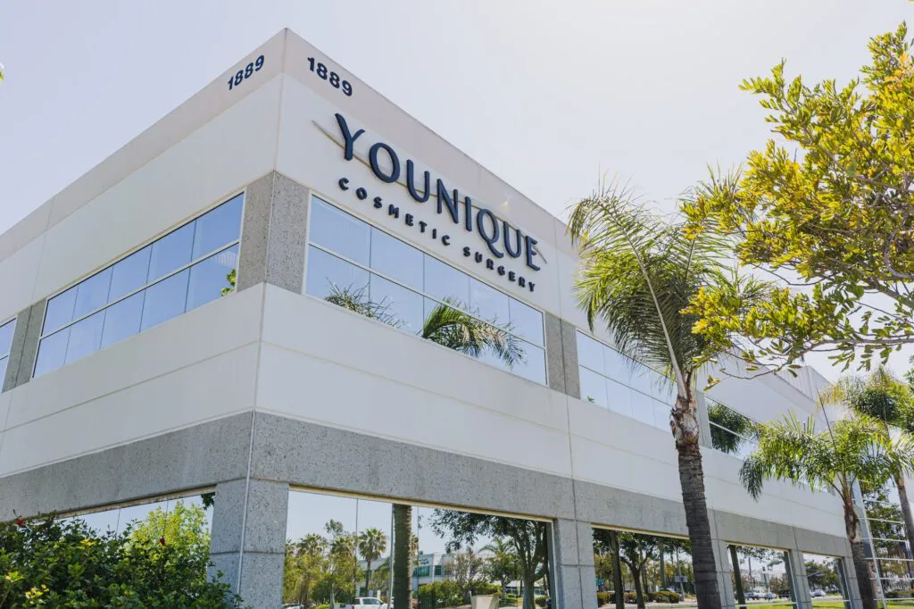 Modern building of a cosmetic surgery center surrounded by palm trees.