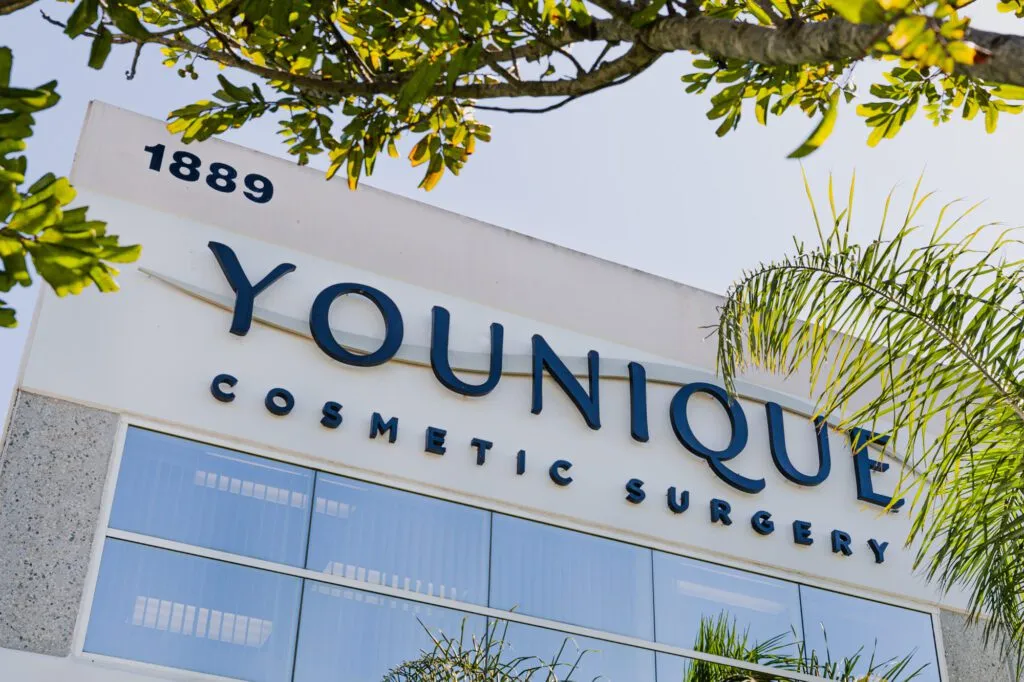 Exterior of Younique Cosmetic Surgery Center with palm trees.