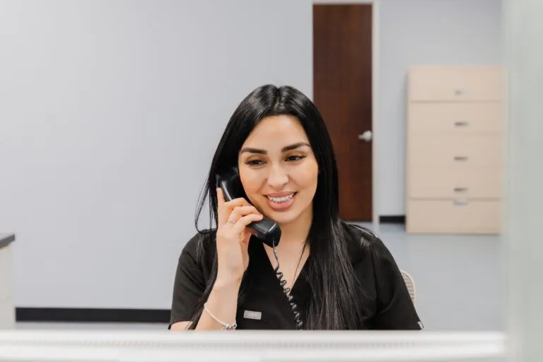 Receptionist answering phone at plastic surgery center.
