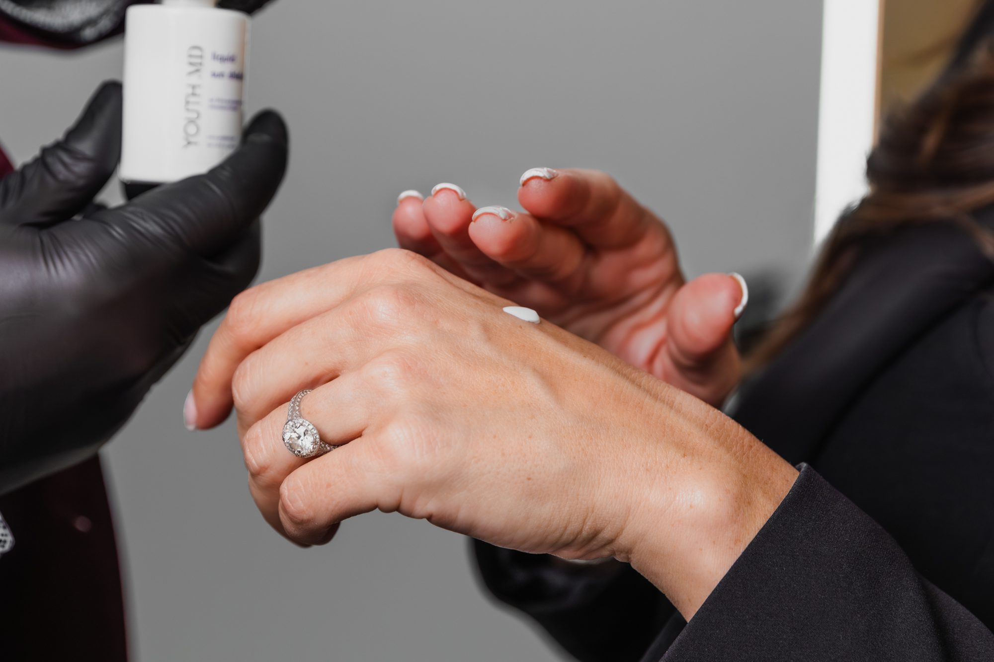 Application of skincare cream on hand at a plastic surgery center.