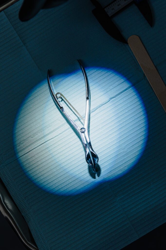 Surgical forceps on a blue surgical drape.
