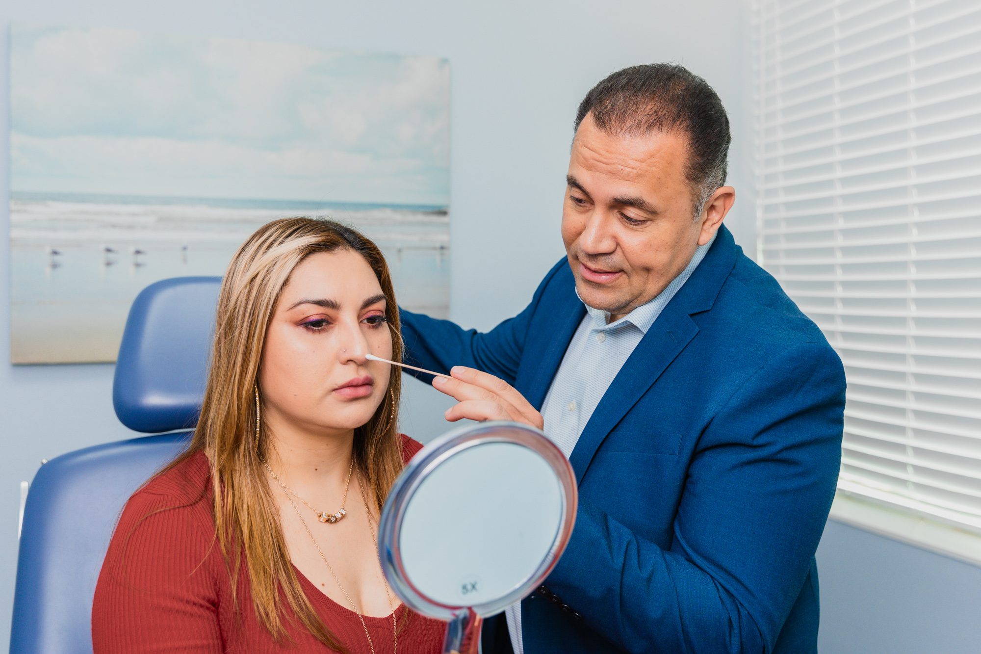 Plastic surgeon consulting with a female patient for nose treatment in clinic setting.