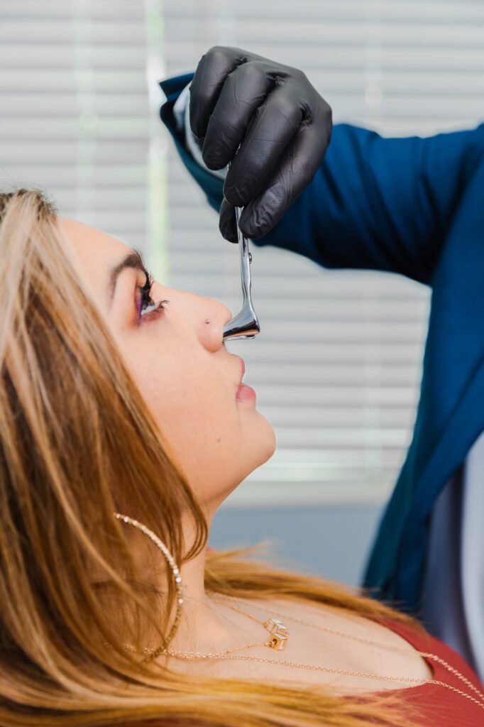 "Profile of woman receiving nose examination by professional wearing black gloves."