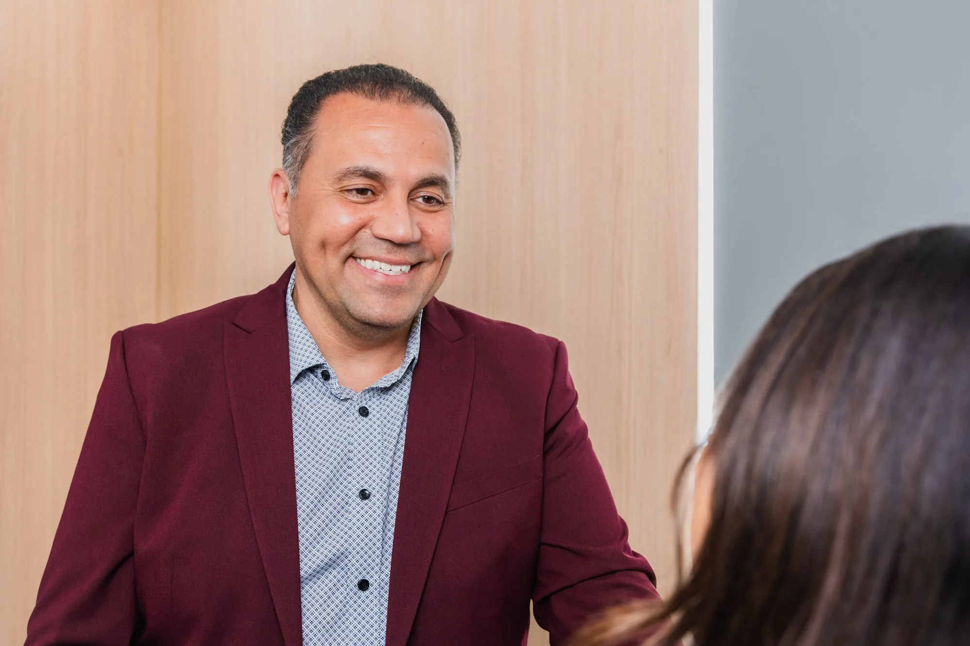 Smiling plastic surgeon consulting with a patient in a modern office.