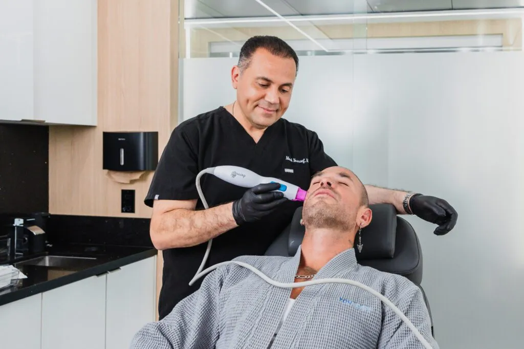 A man receiving a non-invasive facial treatment in a modern clinic setting.