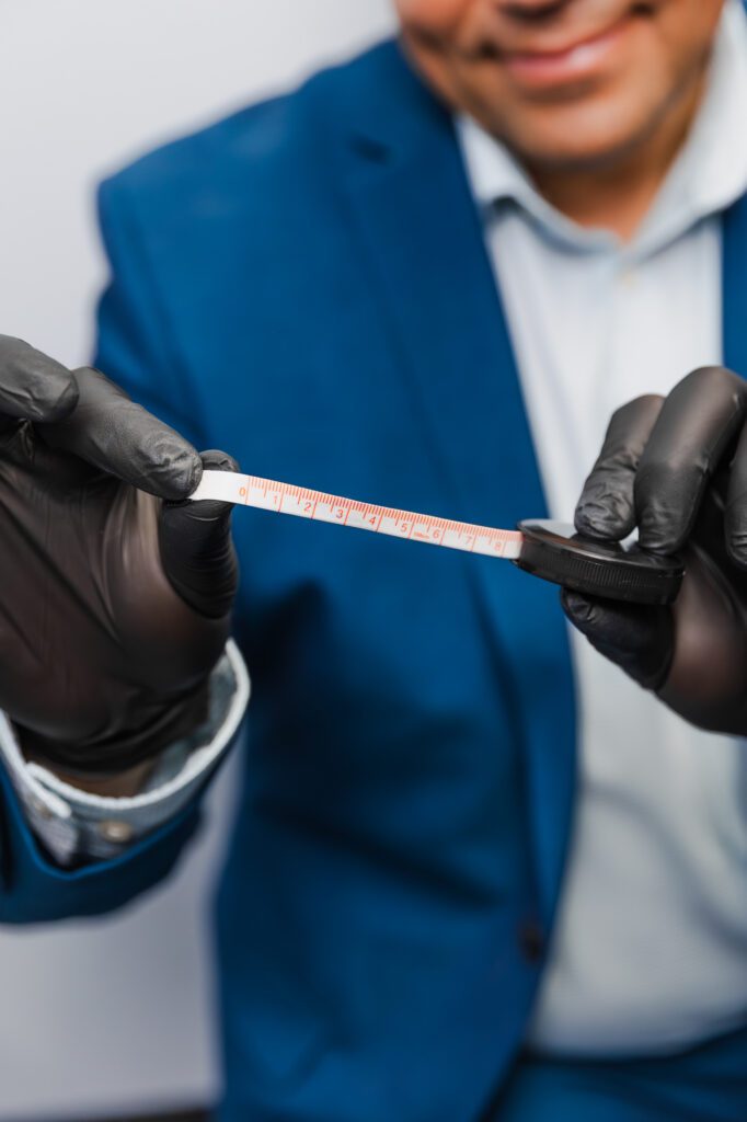 Plastic surgeon measuring with tape, emphasizing precision in cosmetic procedures.