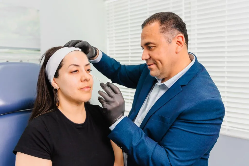 Plastic surgeon consulting with a woman for a cosmetic procedure in a clinic office.