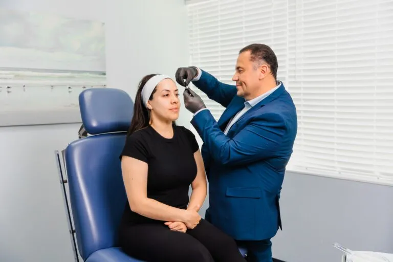 Plastic surgeon consulting with a patient in a clinic setting.